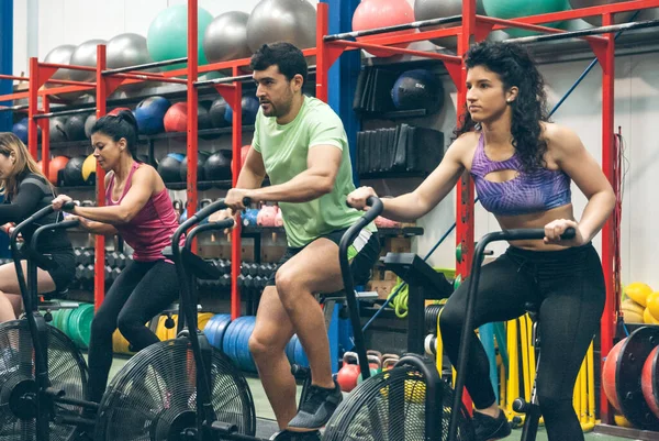 Athletes doing air bike indoor — Stock Photo, Image