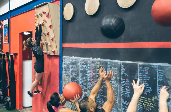 Sportkvinna Träning Hänger Klätterväggen Gymmet Och Klasskamrater Gör Väggboll — Stockfoto