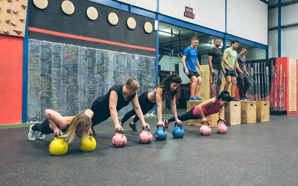 Sportovní ženy trénink s kettlebells a sportovci dělat box jumps — Stock fotografie