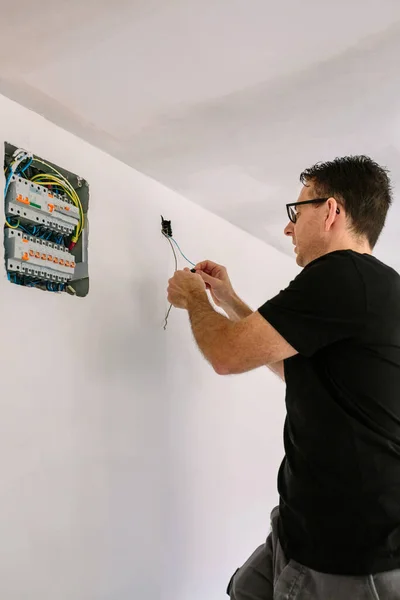 Electricista trabajando en la instalación eléctrica de una casa — Foto de Stock