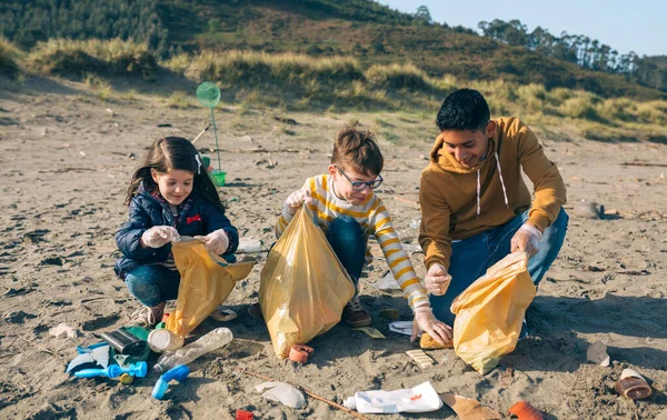 Jonge vrijwilligers die het strand schoonmaken — Stockfoto