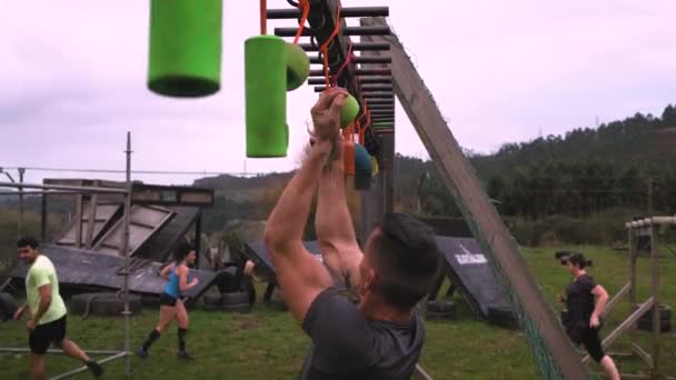 Carrera de obstáculos participante haciendo suspensión — Vídeos de Stock