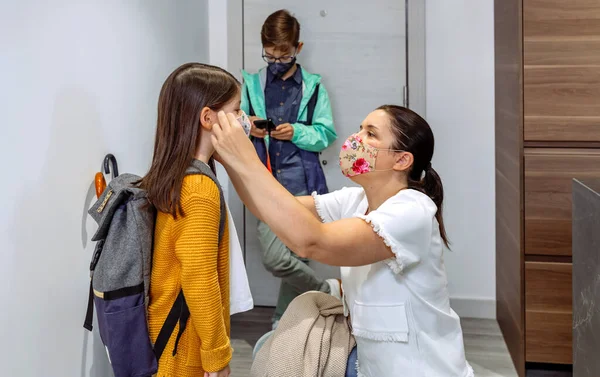 Mutter setzt ihrer Tochter die Maske auf — Stockfoto