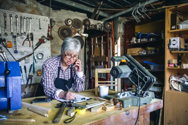 Vrouwelijke timmerman in haar werkplaats — Stockfoto