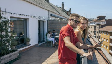 Terasta cep telefonu olan genç iş arkadaşları