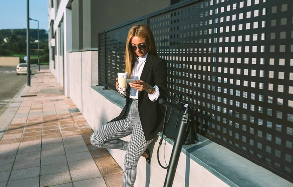 Empresária usando celular e beber café com sua scooter — Fotografia de Stock