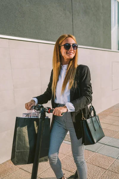 Femme avec sacs à provisions sur scooter électrique — Photo