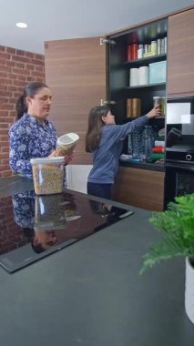 Anne ve kızı, 72 saatlik hayatta kalma kitine baklagiller, tahıllar ve fıstıklar yerleştiriyor. Acil durumlar, gıda kıtlığı, doğal afetler ya da savaş için mutfakta acil yemek kileri hazırlayan aile.