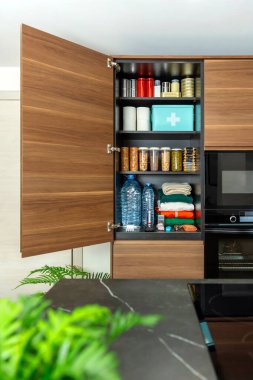 Modern mutfak kileri doğal afetlere, savaşa ya da bilinç kaybına hazır. Açık dolap, içinde konserve yiyecek, su şişeleri, baklagiller, tahıllar, kurabiyeler, ilk yardım malzemeleri ve giysiler bulunan 72 saatlik bir hayatta kalma kiti gösteriyor.