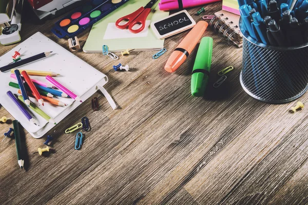 Bunte Schulmaterialien über hölzernen Schreibtisch. Zurück zur Schule — Stockfoto