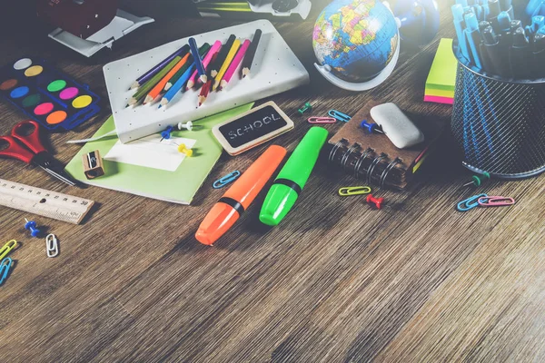 Bunte Schulmaterialien über hölzernen Schreibtisch. Zurück zur Schule — Stockfoto