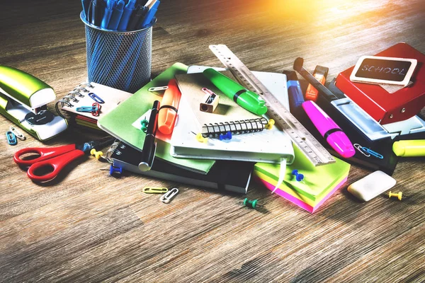 Bunte Schulmaterialien über hölzernen Schreibtisch. Zurück zur Schule — Stockfoto