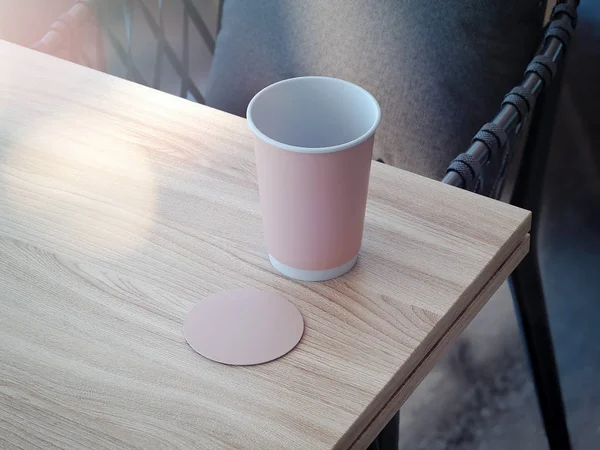 Copo de café rosa e mockup montanha-russa deitado sobre a mesa de madeira, renderização 3d — Fotografia de Stock