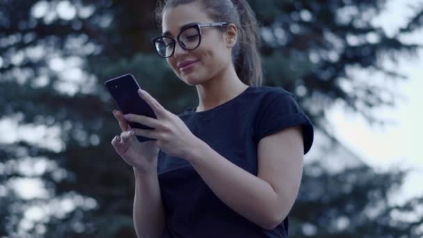 Приваблива молода жінка в окулярах спілкується з друзями . — стокове відео
