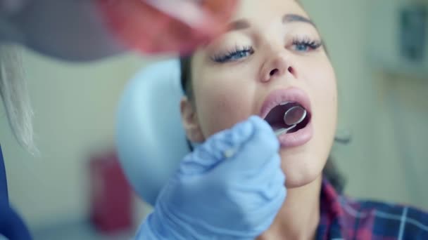 Dentista examinando os dentes do paciente usando espelho na clínica — Vídeo de Stock