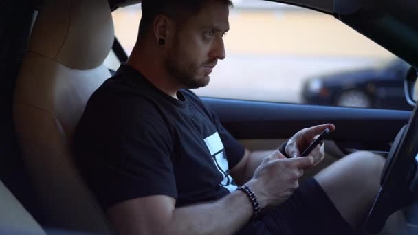 Homem jovem muscular conversando pelo telefone inteligente — Vídeo de Stock