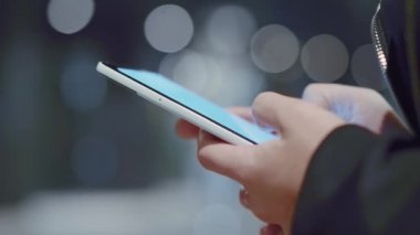 Kadın elinde cep telefonu tutarak yakın çekim.