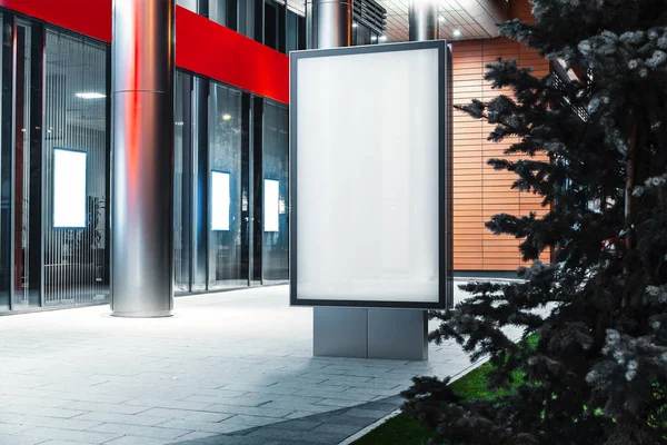 Soporte de pancarta iluminada en blanco junto al edificio moderno por la noche, representación 3D . — Foto de Stock