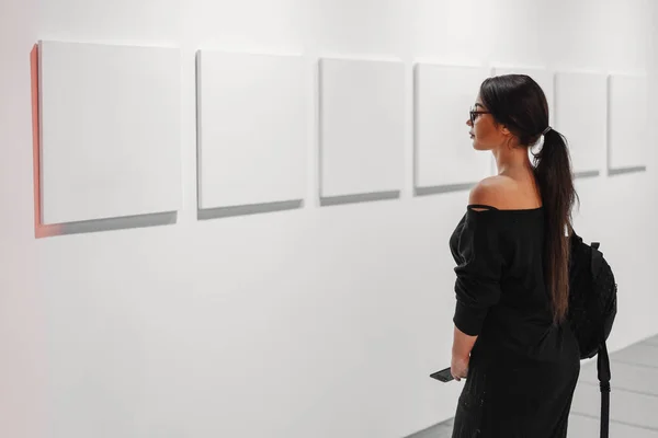 Крупним планом жінка дивиться порожні полотна плакати на стіні в художній галереї . — стокове фото