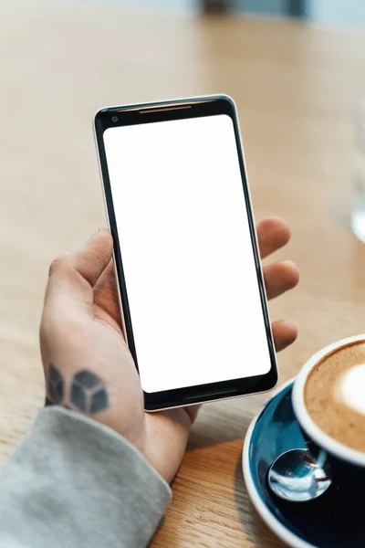 Close up de homem tatuado mãos segurando telefone celular com tela em branco . — Fotografia de Stock