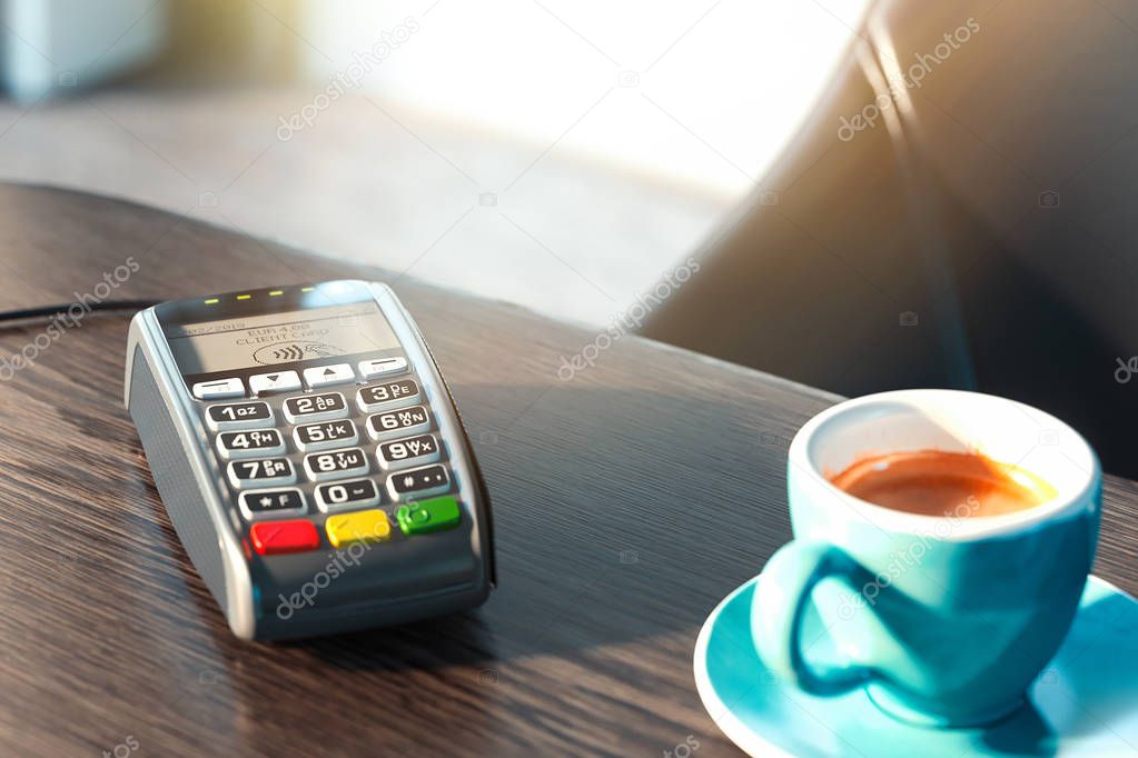 POS payment terminal and mobile phone in modern cafe. NFC payments concept. 3d rendering. Coffee cup is on foreground.