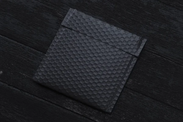 Paquete negro sobre fondo negro. renderizado 3d. espacio de copia. Espacio vacío . — Foto de Stock