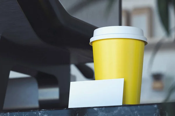 Takeaway coffee cup and blank business card in bright modern cafe. 3d rendering. — Stock Photo, Image