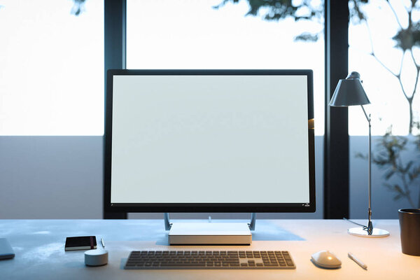 PC avec écran vierge, clavier et souris d'ordinateur sous la lampe. Rendu 3d . — Photo