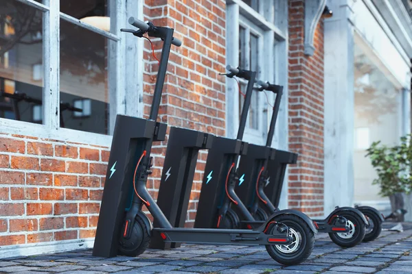 Electric scooter with electric chargeron cityscape. eco alternative transport concept. 3d rendering. — Stock Photo, Image