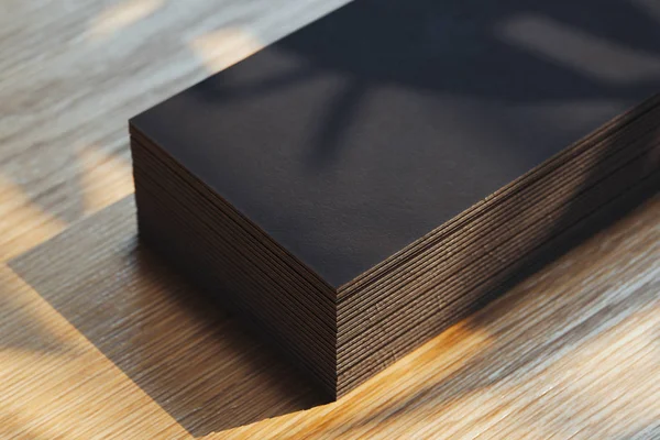 Close up of black blank business cards set isolated on wooden background, 3d rendering. — Stock Photo, Image