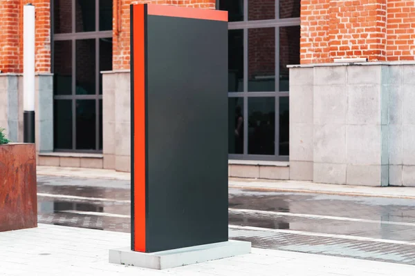 Boş siyah açık afiş modern binanın yanında duruyor. 3d render.