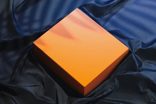 Primer plano de la caja en blanco naranja sobre tejido oscuro. Copiar espacio. Espacio vacío. renderizado 3d . —  Fotos de Stock