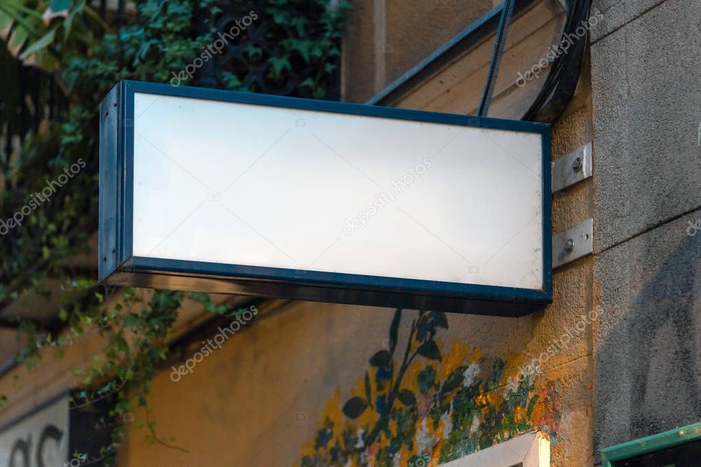 Blank white store signboard mockup. Empty shop signage mounted on the ancient wall. Street sign