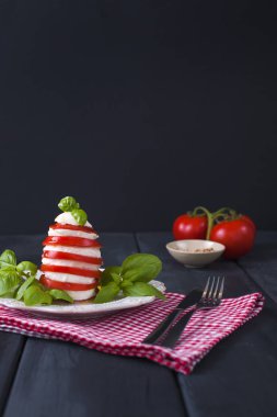domates, mozzarella peyniri, fesleğen ve siyah arka plan üzerine zeytin yağı. İtalyan caprese Salatası tarifi Malzemeler.