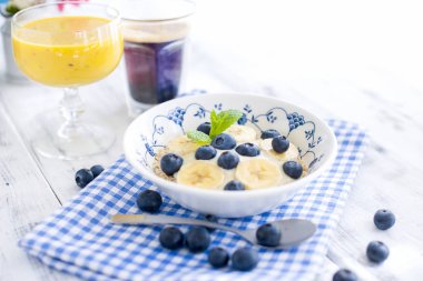 Lezzetli breakfast kompozisyon. Muz, linseeds, taze meyve, kahve, fover rustik ahşap zemin, kopya alanı ile organik müsli kase. Üstten görünüm