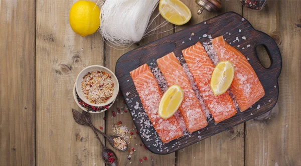 Filet de saumon cru avec pain sucré au poivre et sel sur papier cuisson thème rustique avec copie-espace. Pose plate — Photo