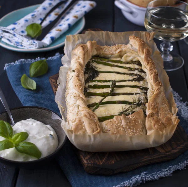 Torta aperta con asparagi e formaggio e un bicchiere di vino bianco. Bandiera. Posto per il testo. Foto scura. Copia spazio — Foto Stock