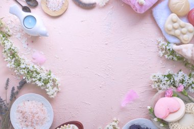 Spa. Farklı kozmetik bakım ve güzellik için. Pembe bir arka plan ve çiçekler. Metin için yer. Çerçeve