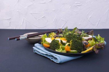 Salata sebze, siyah bir zemin üzerine gelen. Vejetaryen yiyecekler. Çin yemeği. Sağlıklı öğle yemeği. Metin için yer.