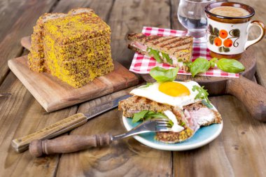 Yumurta ve fesleğen kahvaltı ile tahıl ekmek için tat. Aromalı kahve. Bölümü bir çatal ve bıçak. Vintage Fotoğraf. Metin ve kırsal arka plan için yer.