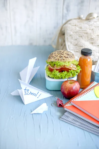 Sandwich for school lunch and juice, healthy lunch. School books on the table. Copy space.