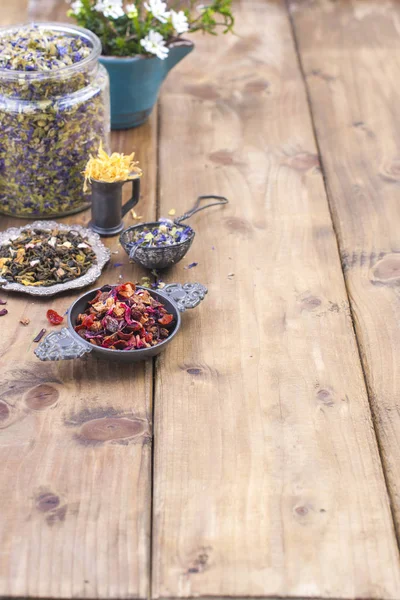 Assorted dried flowers and tea on a wooden background. Natural health. Aromatherapy. Free space for text. Copy space.