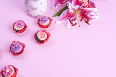 Bir buket lily çiçek, pembe bir arka plan, bir fincan sabah kahve ve kahve kap. Metin için özgür yer. Yat, alanı Kopyala