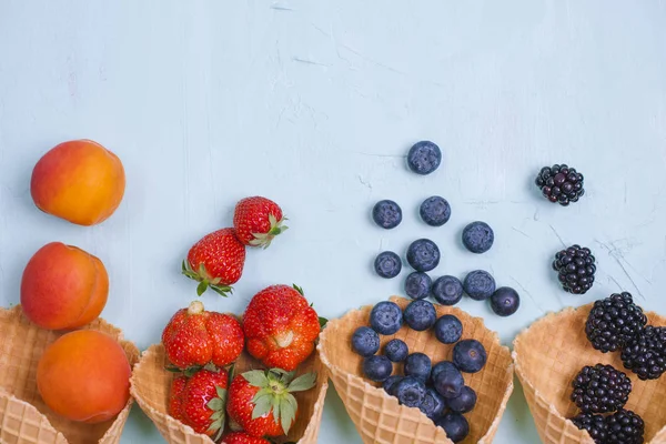 Las bayas diferentes y las frutas sobre el fondo azul. Espacio libre para texto. Copiar espacio. Puesta plana —  Fotos de Stock