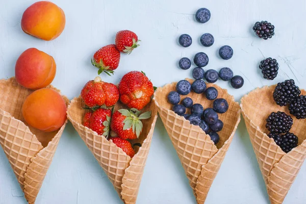 Verschiedene Beeren und Früchte auf blauem Hintergrund. Freiraum für Text. Kopierraum. flache Lage — Stockfoto