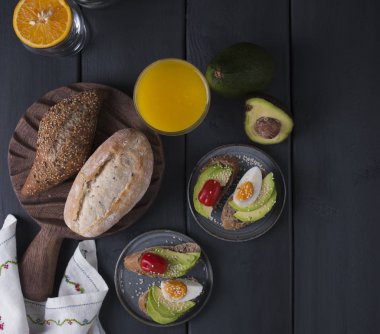 Avokado, yatsom ve kiraz domates, siyah ahşap zemin ile tost. Sağlıklı ve lezzetli yemekler. Fitness Gıda. Yukarıdan görüntüleyin. Düz yatıyordu