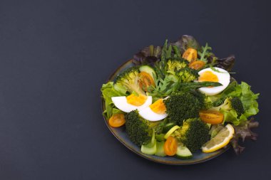 Salata sebze, siyah bir zemin üzerine gelen. Vejetaryen yiyecekler. Çin yemeği. Sağlıklı öğle yemeği. Metin için yer. kopya alanı.