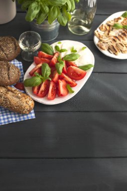 Salata caprese, taze fesleğen ve tahıl ekmeği siyah bir arka plan ile. Alanı, düz yatıyordu kopyalama.