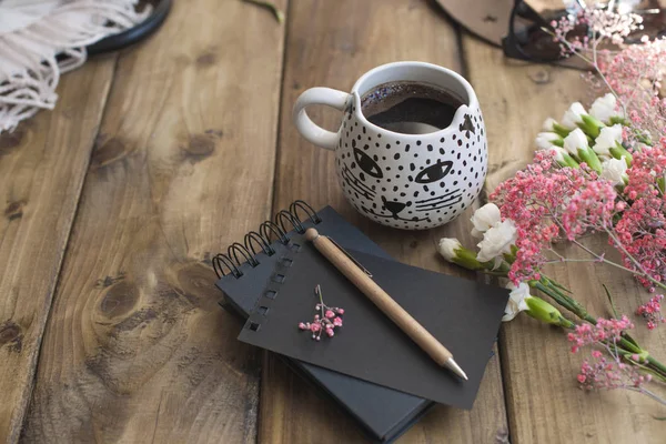 Café fragrante preto, flores, chapéu e óculos. Bom dia, cores ensolaradas. Acessórios femininos e bloco de notas com uma caneta. Planejamento do dia . — Fotografia de Stock