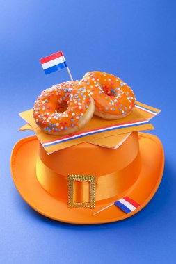 Kings günü kutlama Hollanda. Eğlenceli tatil. Turuncu tatlı çörek ve mavi bir arka plan ve bayraklar bir şapka. Metin için özgür yer. Sivol tatil.
